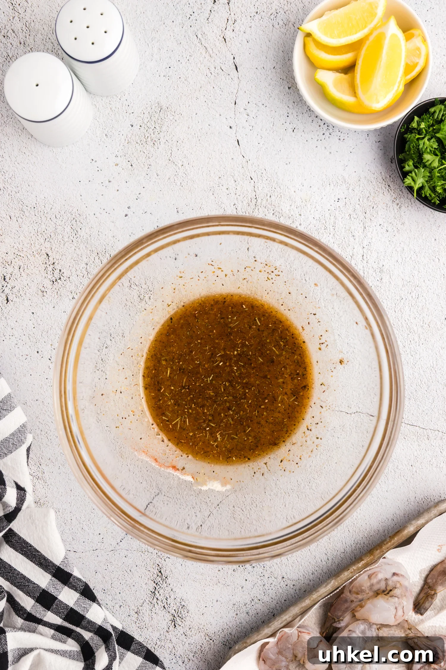 Seasoning mixture blended into a marinade inside a glass mixing bowl.