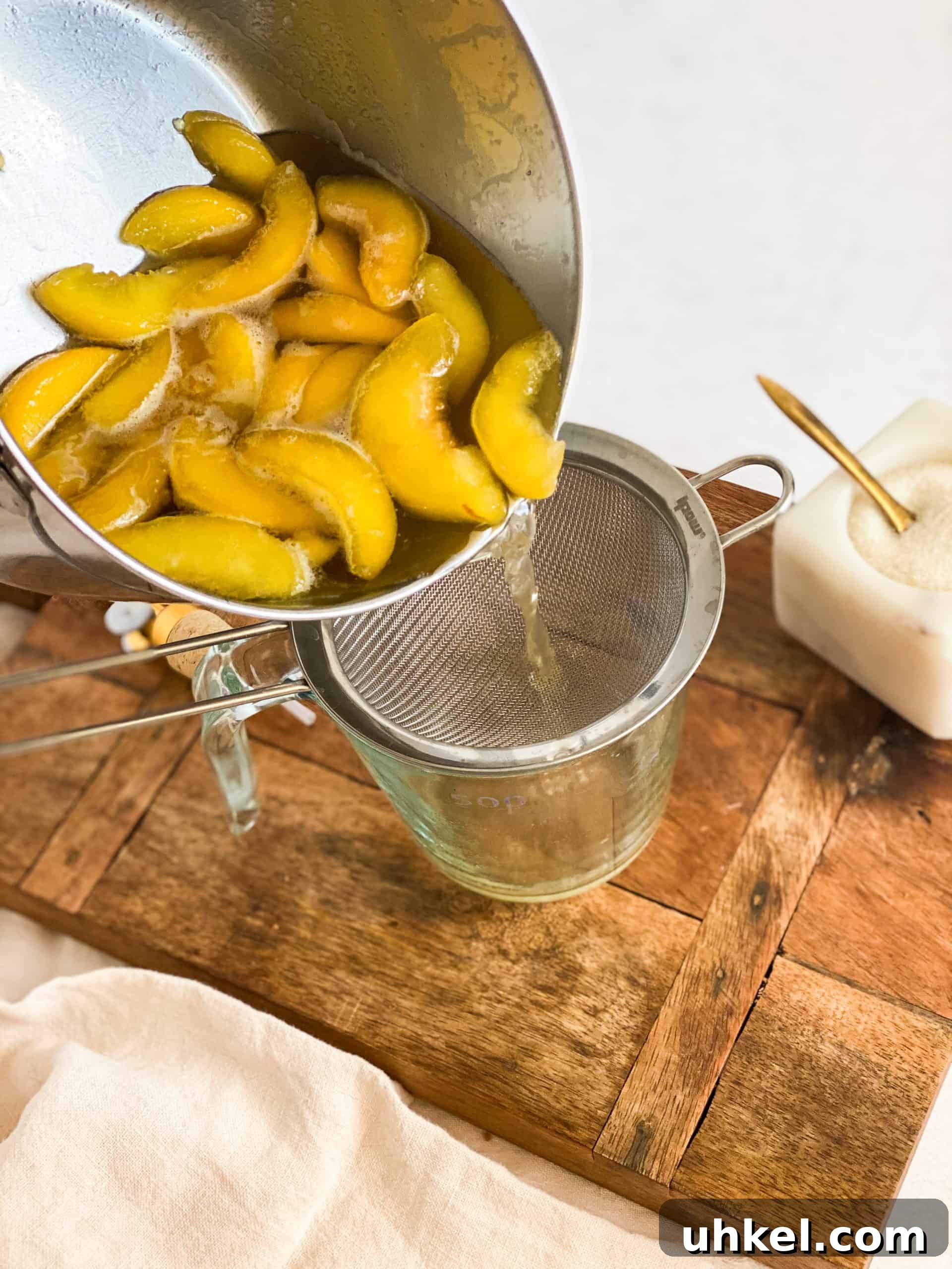Homemade Peach Simple Syrup Recipe for Cocktails & Desserts 5 Peach Simple Syrup being poured into a strainer