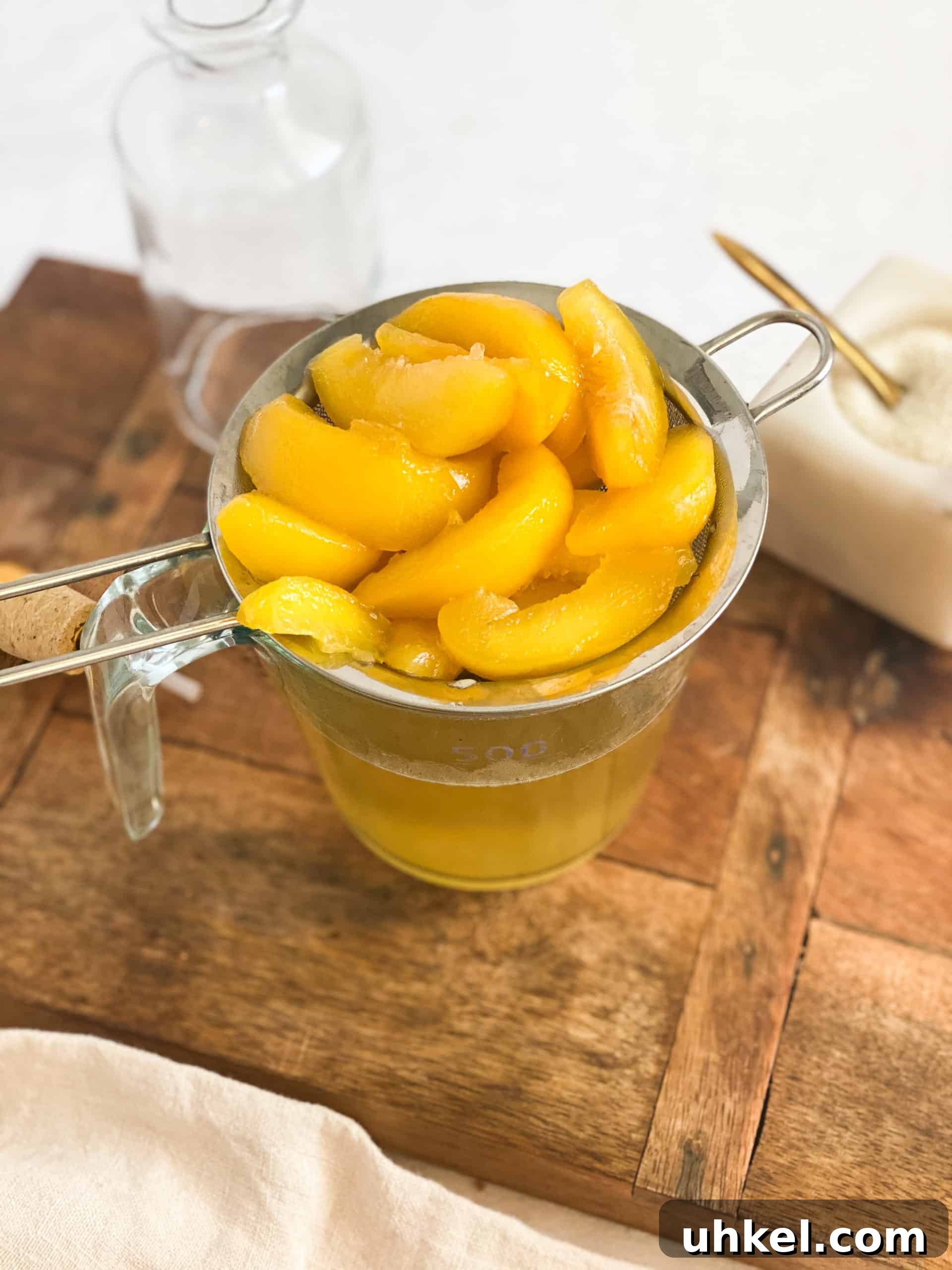 Homemade Peach Simple Syrup Recipe for Cocktails & Desserts 6 Peach Simple Syrup peaches in a strainer