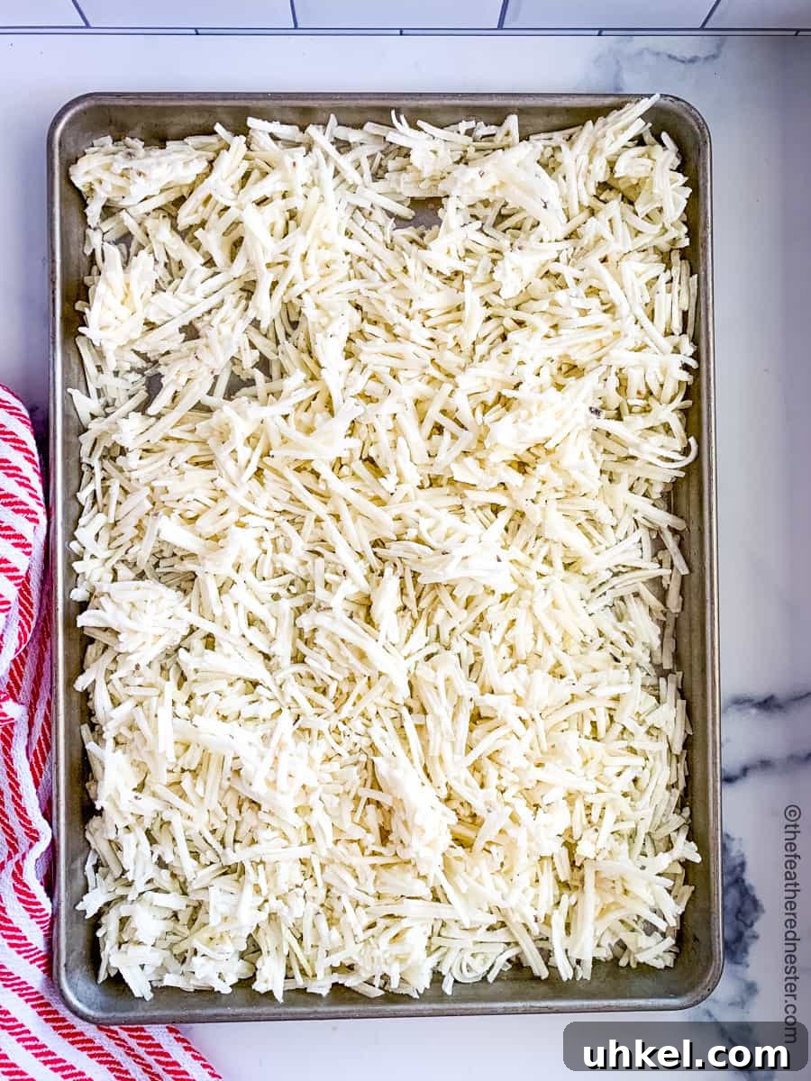Crispy Hash Brown Chicken Casserole with Cheesy Topping 5 a baking sheet of frozen hash brown potatoes.