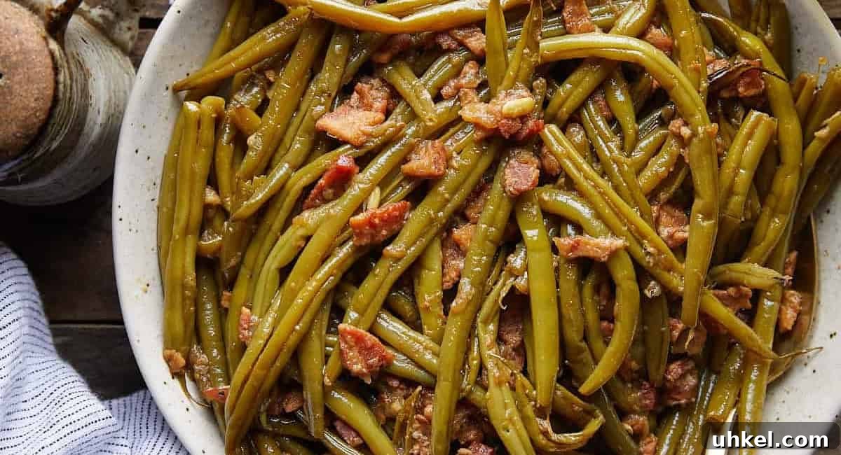 Overhead image of crockpot green beans in white dish. 