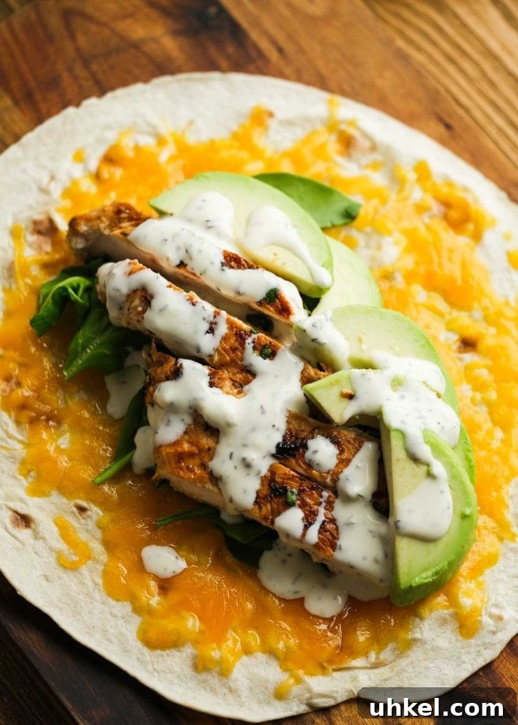 Chicken and Avocado Wrap Recipe for Quick Weeknight Meals 6 chicken avocado wrap laying open on wooden cutting board