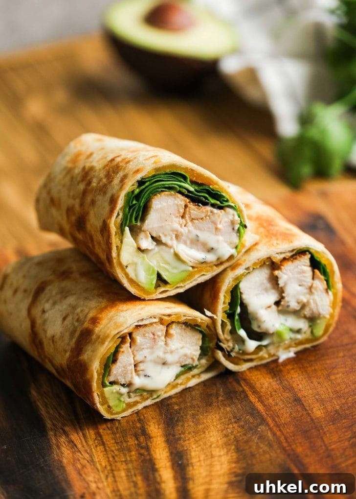 Chicken and Avocado Wrap Recipe for Quick Weeknight Meals 7 Three chicken avocado wraps stacked on a wooden cutting board