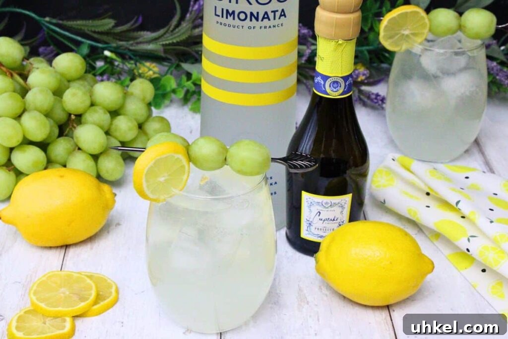 Cîroc Lemonade Spritzer Recipe — Refreshing Vodka Limonata Spritz 3 vodka lemonade spritzer with fruit garnish next to vodka and prosecco bottle surrounded by fresh spring decor