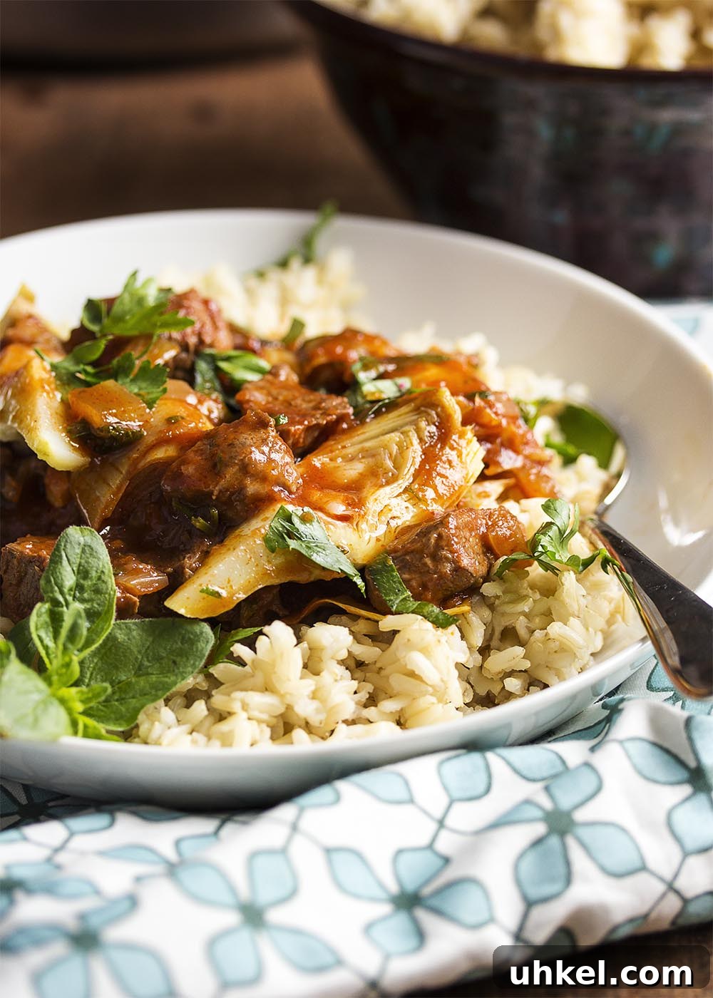 Lamb and Artichoke Stew A bowl of spring lamb stew over brown rice with a spoon in the bowl.