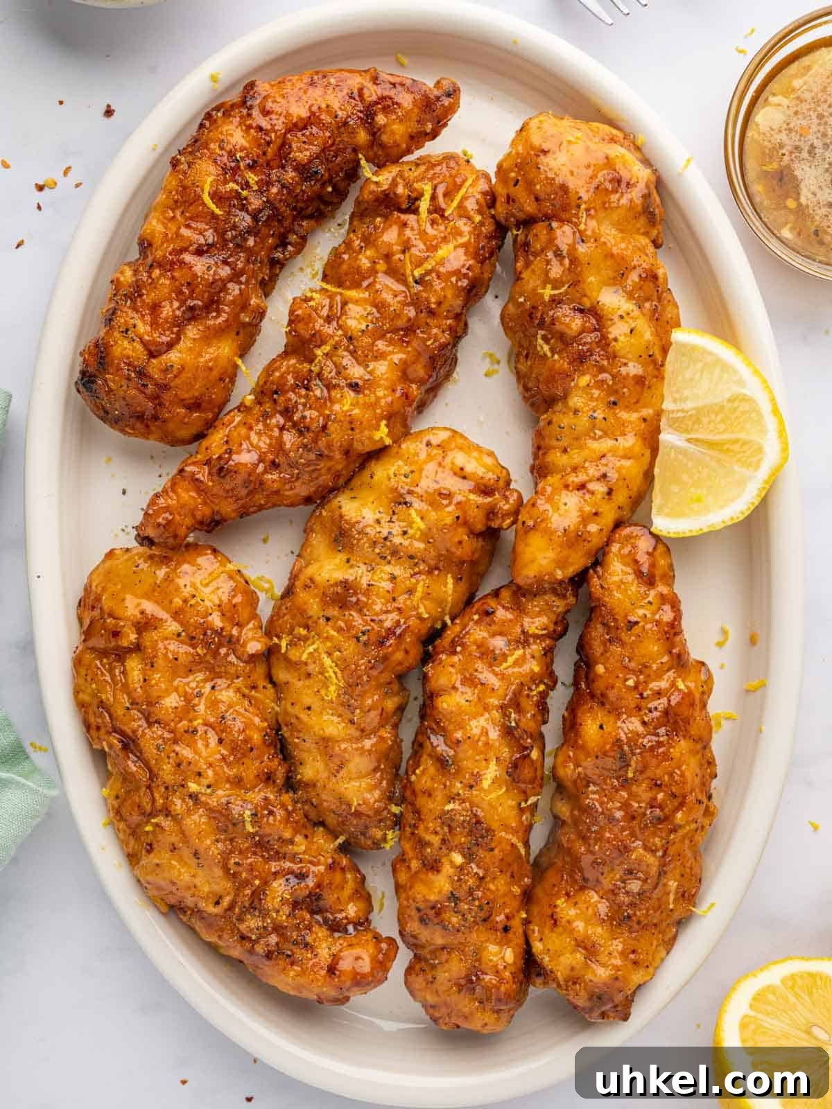Crispy Lemon Pepper Chicken Strips Recipe 2 Crispy baked lemon pepper chicken strips with honey glaze.