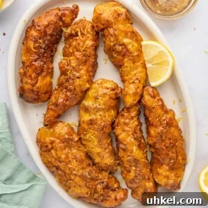 Crispy Lemon Pepper Chicken Strips Recipe 13 Lemon pepper chicken fingers on a platter.