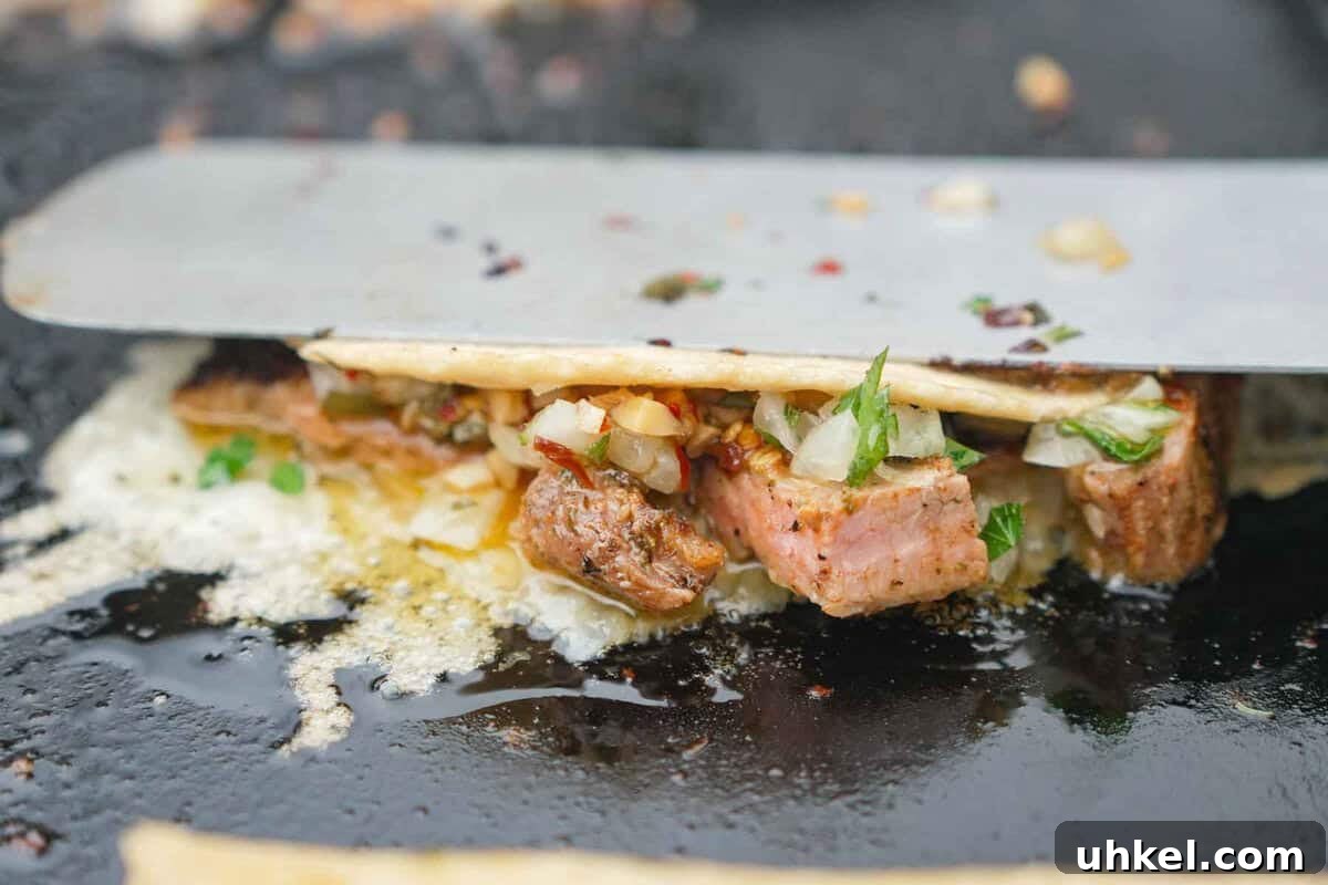 Garlic Shrimp Tacos with Spanish Flavors 11 Using a spatula to sear a Spanish garlic oil taco on the griddle