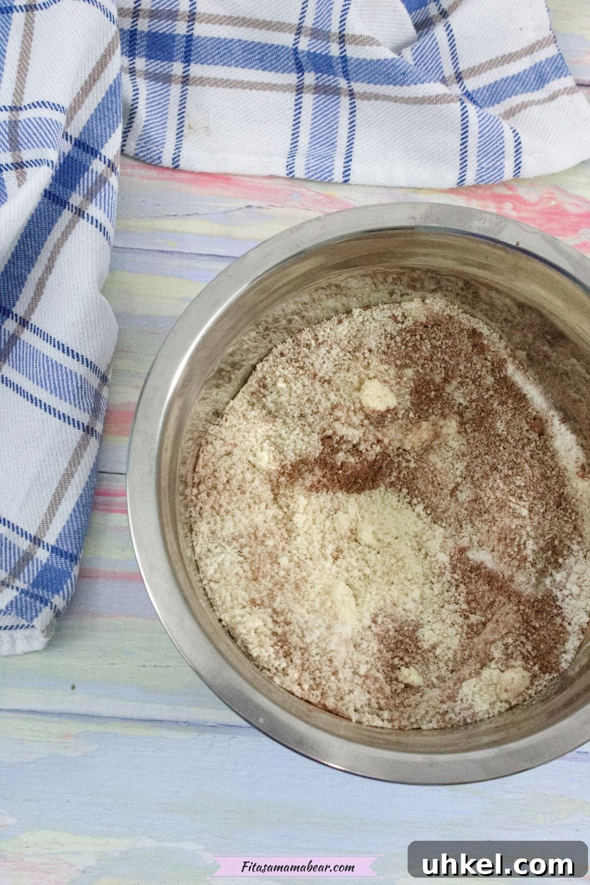 High-Protein Gluten-Free Brownies for Chocolate Lovers 4 Steel bowl with a blend of flour and cacao powder and a blue linen behind it