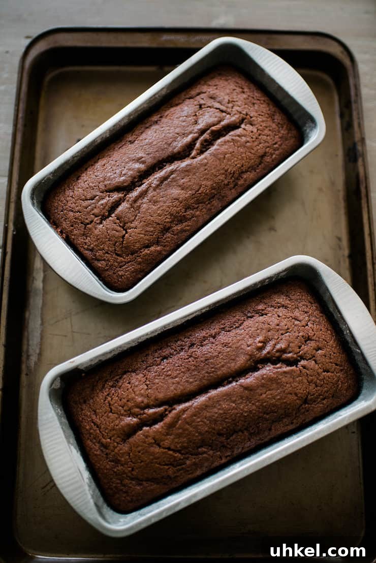 Moist Chocolate Loaf with Bourbon Glaze Recipe 4 two bread loaf pans with baked chocolate breads on a sheet pan