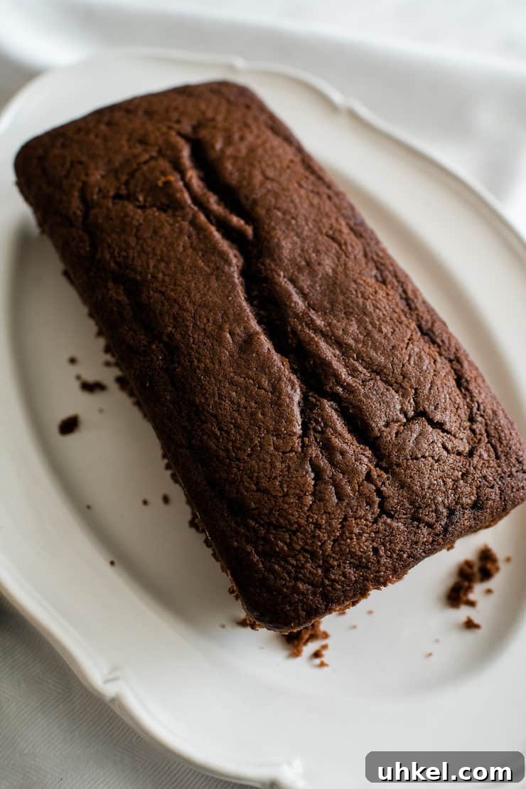 Moist Chocolate Loaf with Bourbon Glaze Recipe 6 unglazed chocolate applesauce bread on a white plate on a white cloth