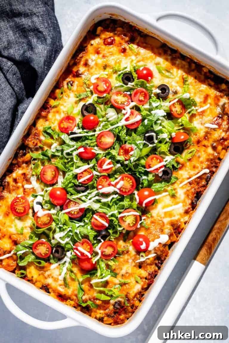 A cheesy beef casserole topped with lettuce, tomatoes and black olives. 