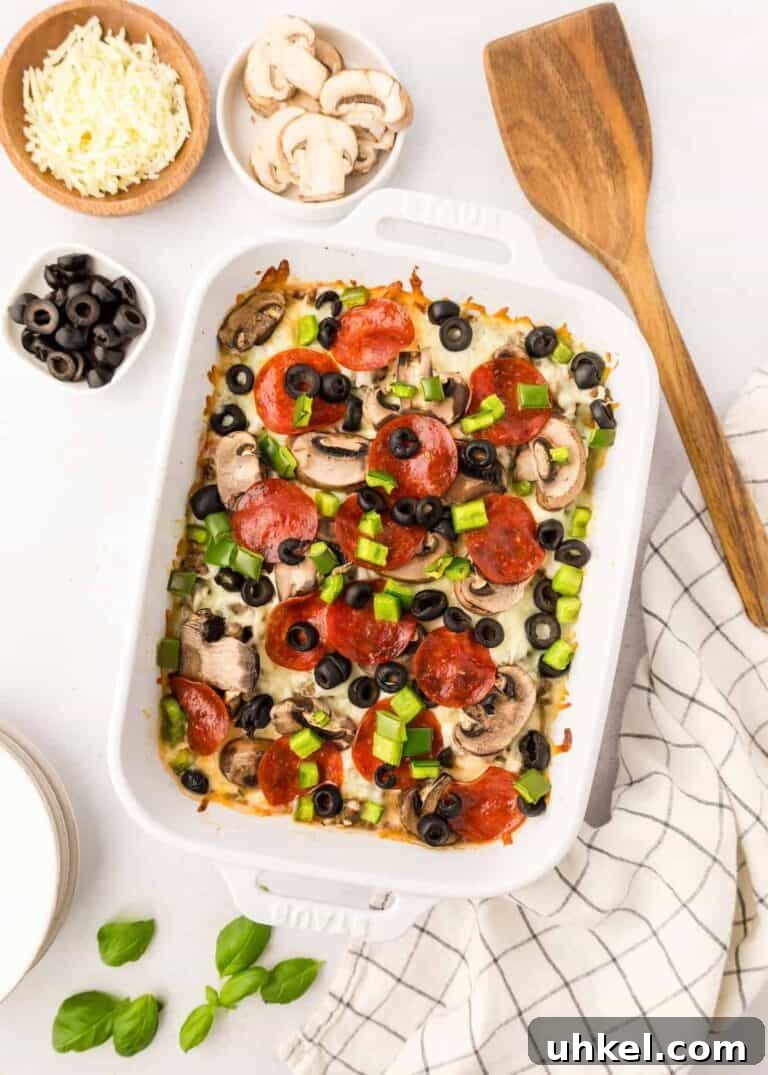 A pizza casserole topped with pepperoni and black olives.