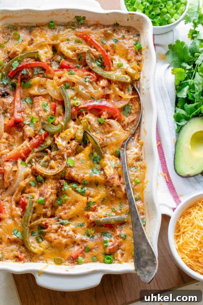 A ceramic baking dish with chicken fajita casserole topped with bell pepper slices. 