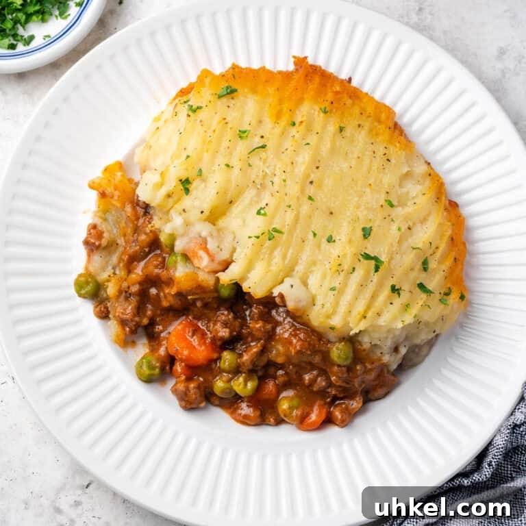 A portion of gluten free cottage pie served on a dinner plate.