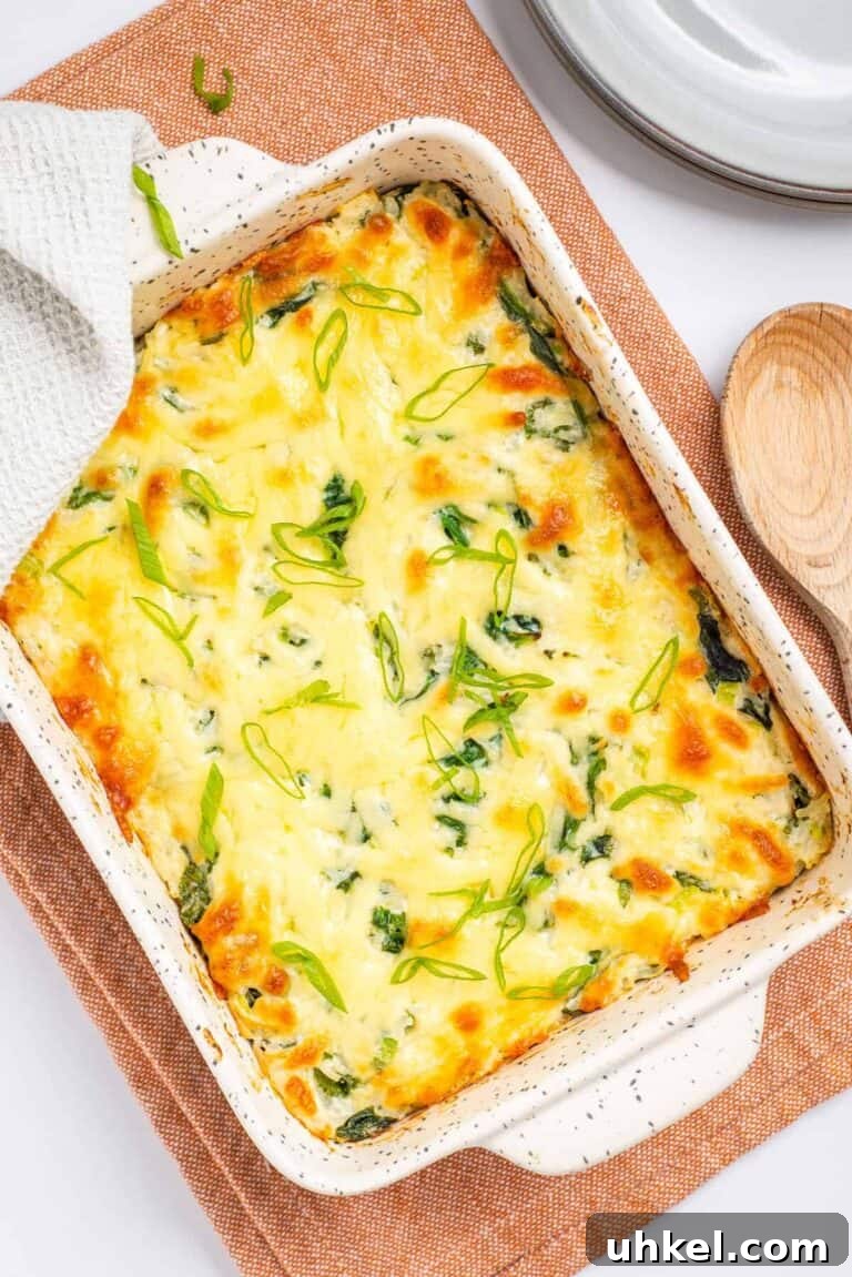 A cheesy rice casserole sitting on a wooden cutting board.