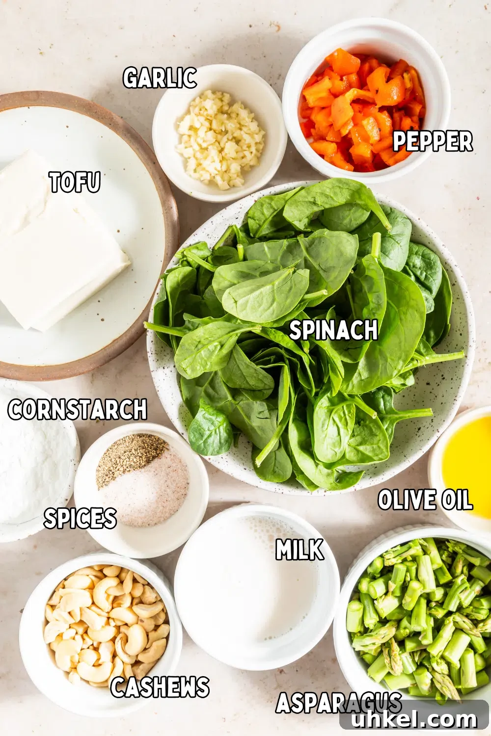Vegan Egg Bites @spabettie #vegan #glutenfree #eggfree #breakfast #recipe Bowls of ingredients to make vegan egg bites: tofu, garlic, pepper, spinach, cornstarch and spices, milk, cashews, asparagus and olive oil.