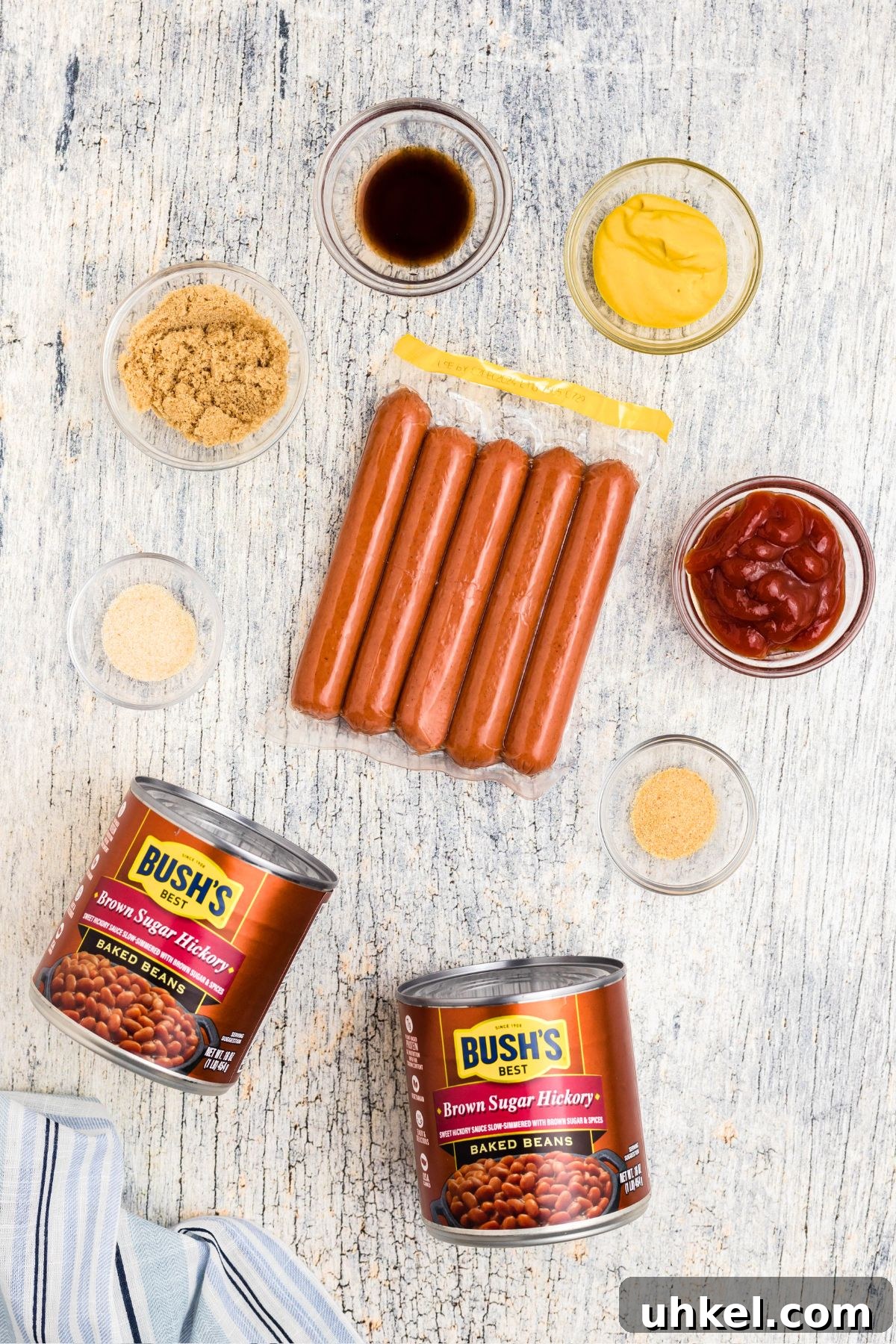 Classic Beanie Weenies Recipe with Flavorful Tomato Sauce 3 Ingredients needed to make beanie weenies, measured in small glass bowls.