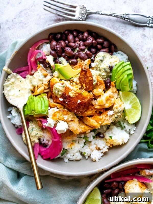 Crispy Baja Shrimp Tacos with Tangy Lime Slaw 6 Grey ceramic bowl with rice, cilantro and fish. Avocado slices and a silver fork.
