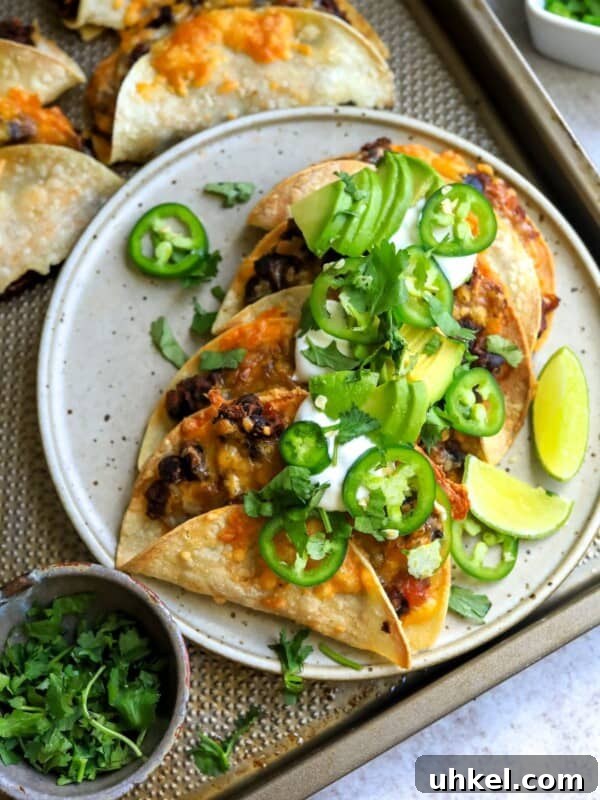 Crispy Baja Shrimp Tacos with Tangy Lime Slaw 9 Crispy Black Bean Tacos on a white plate with limes and cilantro, sour cream and jalapeño.