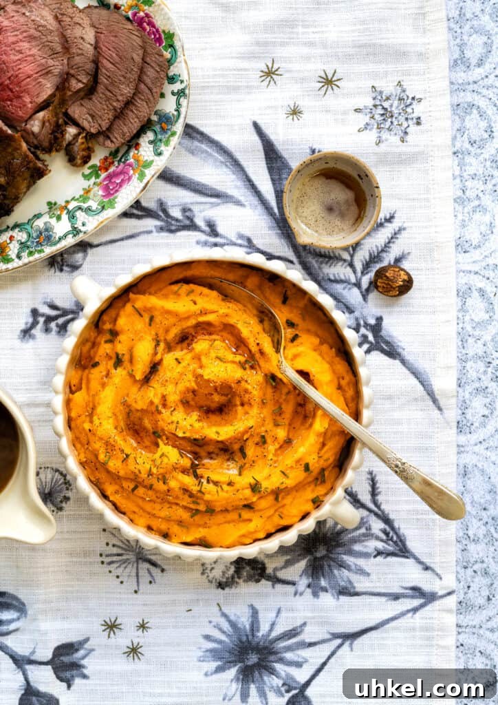 Overhead photo of whipped sweet potatoes in a bowl topped with parsley and butter.
