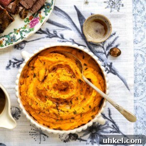 Overhead photo of whipped sweet potatoes in a bowl topped with parsley and butter.