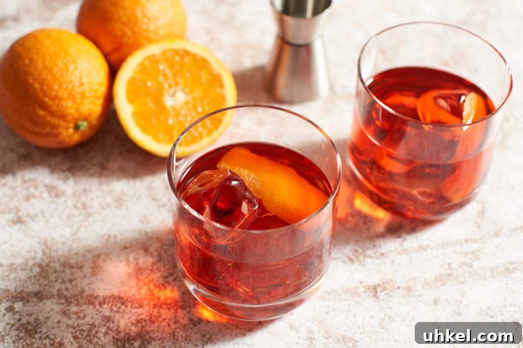 Classic Negroni Cocktail Recipe: How to Mix the Perfect Negroni 2 Two Negroni cocktails with oranges and a cocktail jigger.