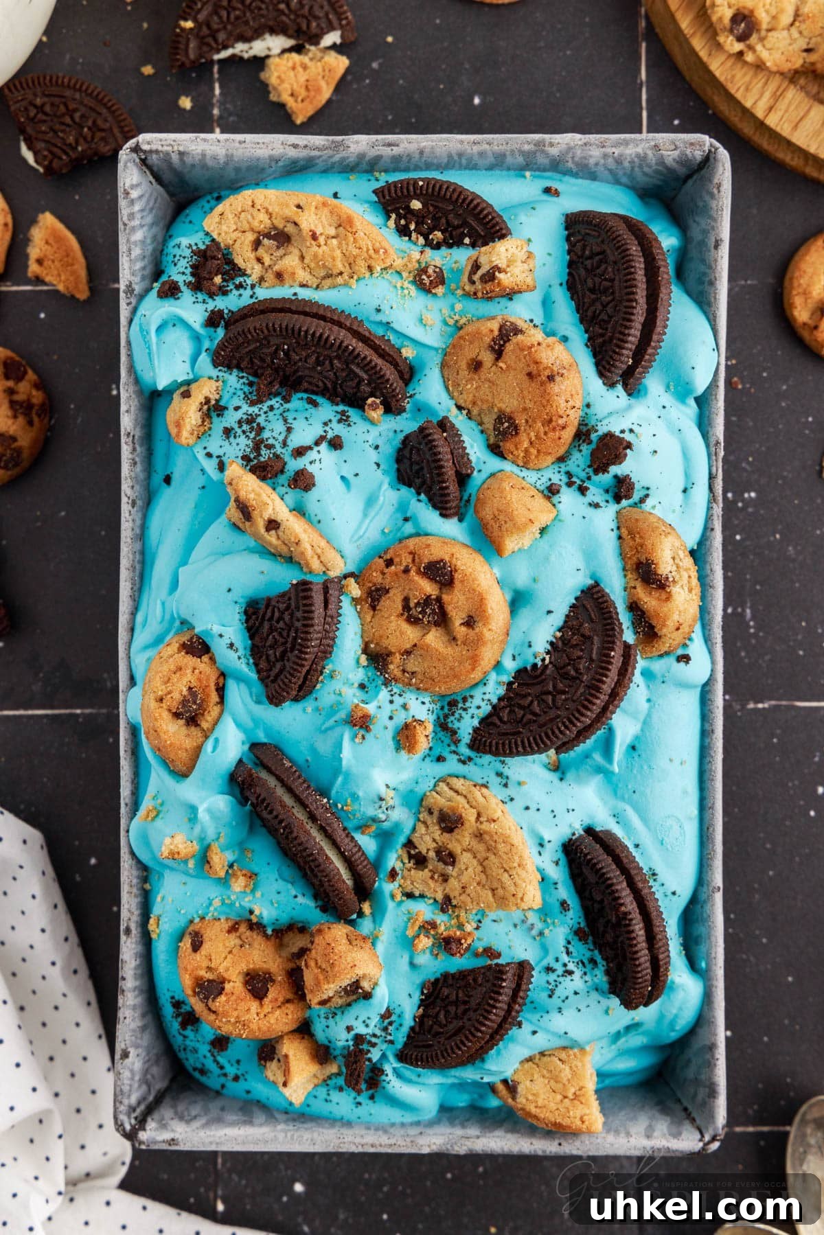 Blue Cookie Monster Ice Cream topped with Oreos and chocolate chip cookies in a loaf pan.
