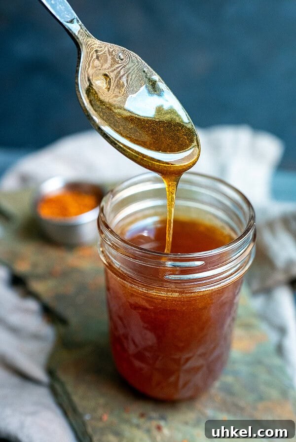 Savory Homemade Dry Rub Recipe for Crispy Chicken Wings 11 Spoon drizzling gochugaru hot honey.