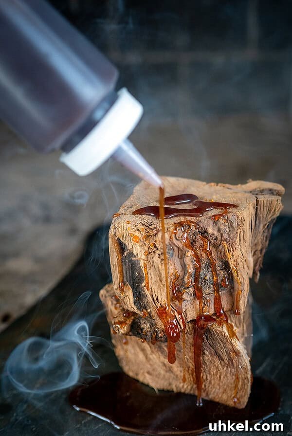 Savory Homemade Dry Rub Recipe for Crispy Chicken Wings 10 Drizzling hot honey on wood with smoke in background.