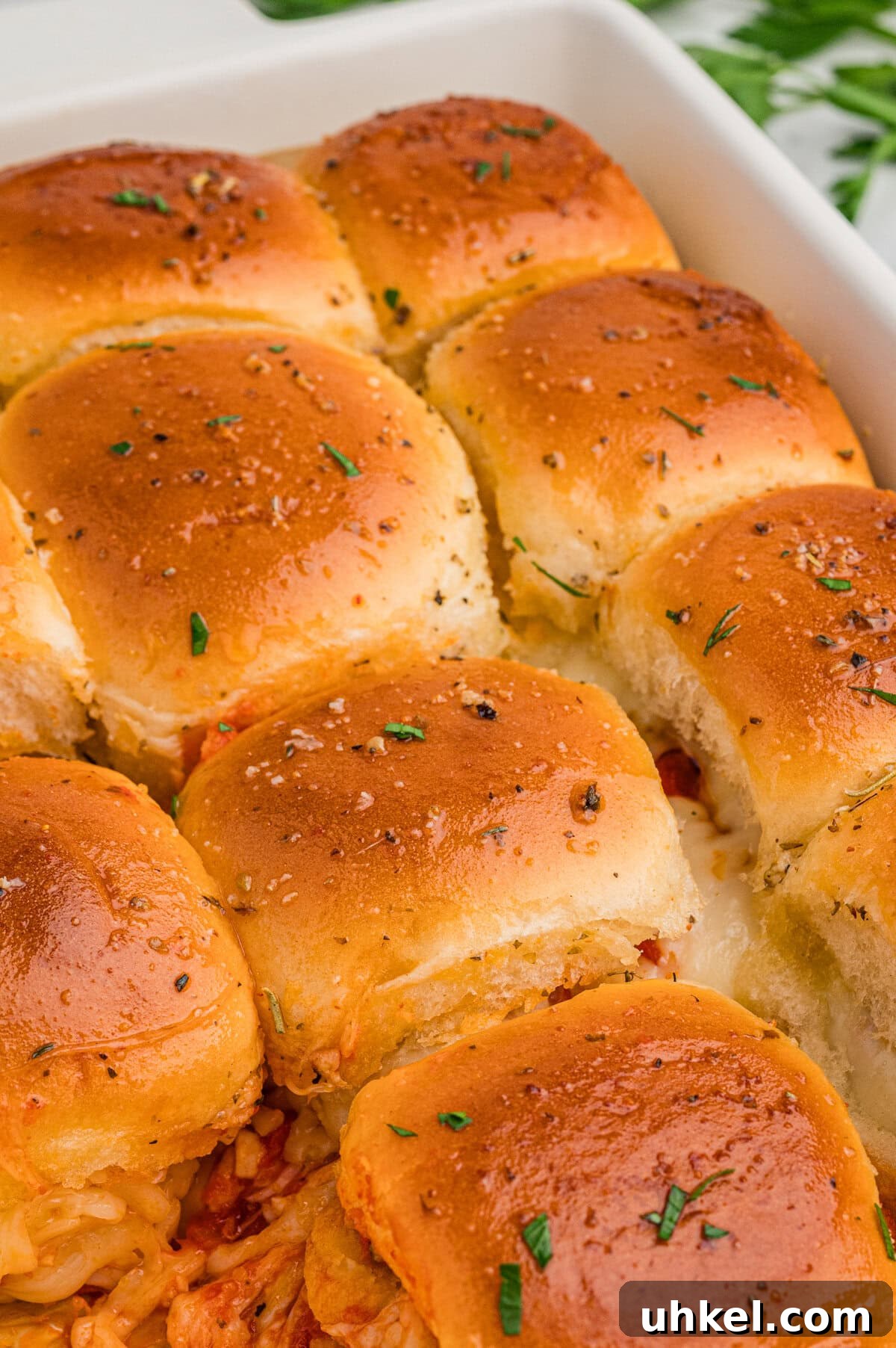 Chicken Parmesan Sliders Recipe: Crispy Mini Sandwiches 3 Chicken parmesan sliders with golden brown buns topped with herbs, and some melted cheese peeks from the edges.