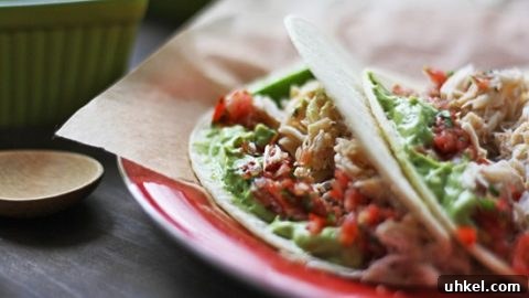 crab tacos with salsa and avocado sauce on a red plate