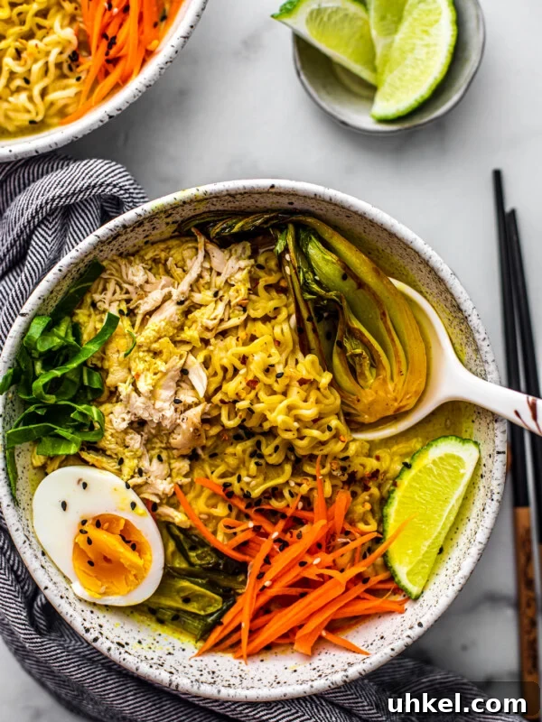 Homemade Ramen Bowl Recipe: Savory Broth & Tasty Toppings 11 Overhead shot of bowl of chicken curry ramen soup with side of limes.