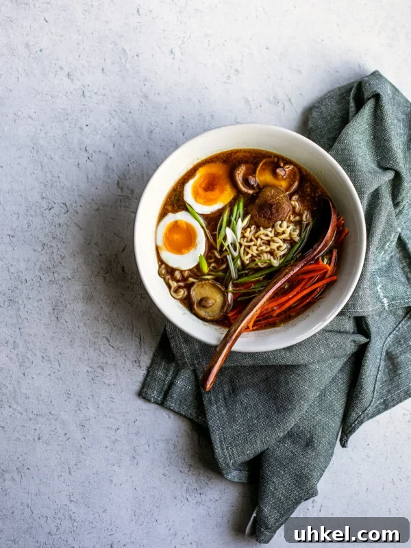 Homemade Ramen Bowl Recipe: Savory Broth & Tasty Toppings 12 Off center shot of bowl of miso ramen with blue dish towel folded around it.