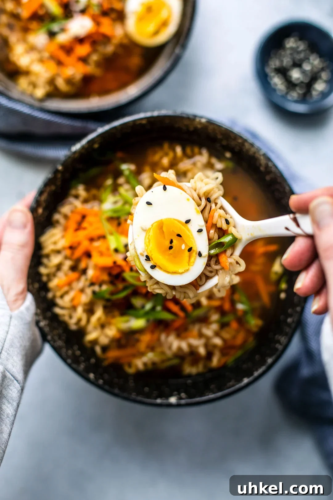 Homemade Ramen Bowl Recipe: Savory Broth & Tasty Toppings 9 Jammy egg being spooned up from ramen soup bowl.