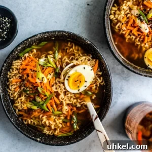 Homemade Ramen Bowl Recipe: Savory Broth & Tasty Toppings 10 Ramen bowl with soft-boiled egg and a pinch bowl of sesame seeds.