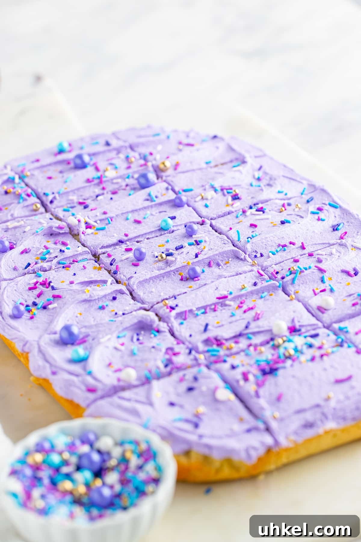 Chewy Frosted Sugar Cookie Bars: Simple Homemade Recipe 3 Frosted sugar cookie bars sliced and ready to serve on a white marble serving platter