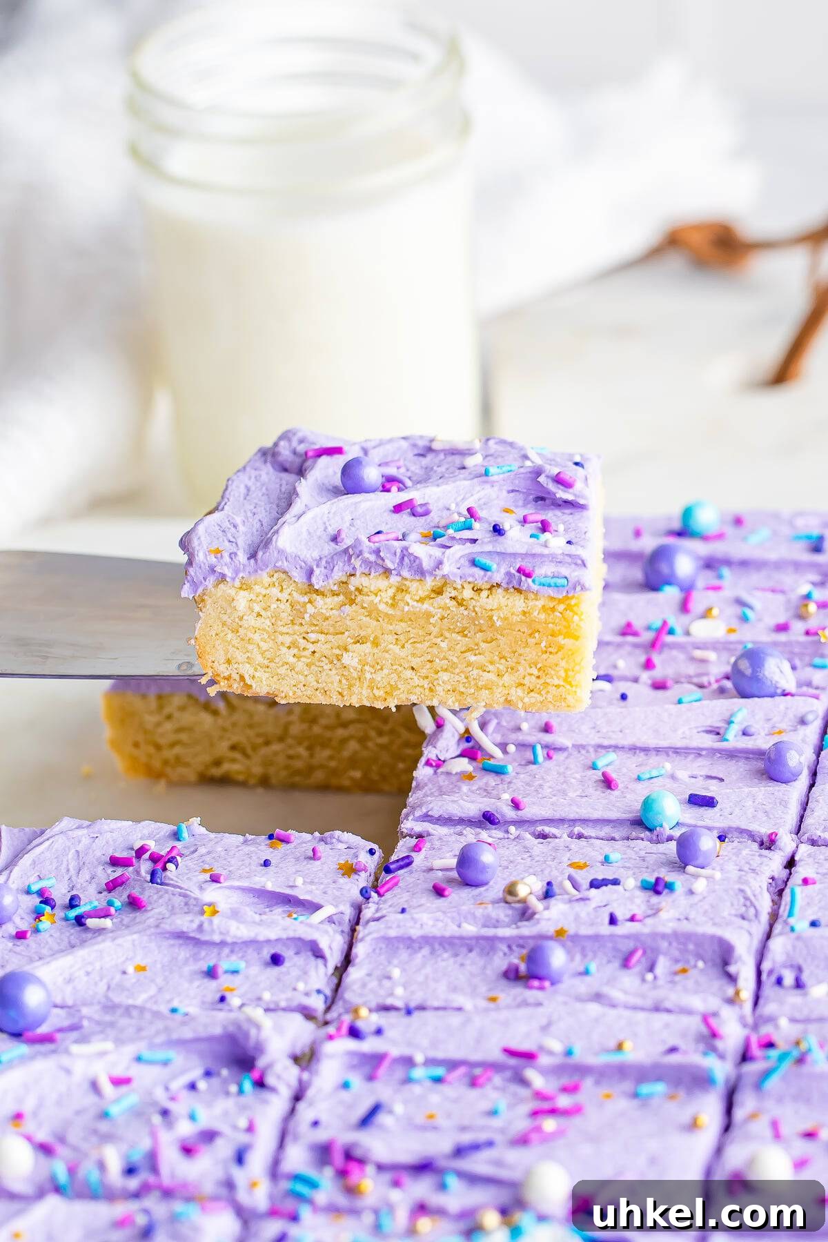 Chewy Frosted Sugar Cookie Bars: Simple Homemade Recipe 7 A spatula holding a frosted sugar cookie bar in air