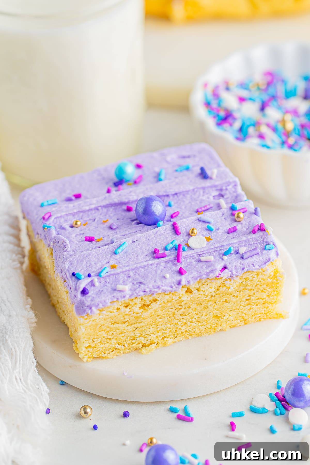 Chewy Frosted Sugar Cookie Bars: Simple Homemade Recipe 8 A frosted sugar cookie bar on a small white marble plate