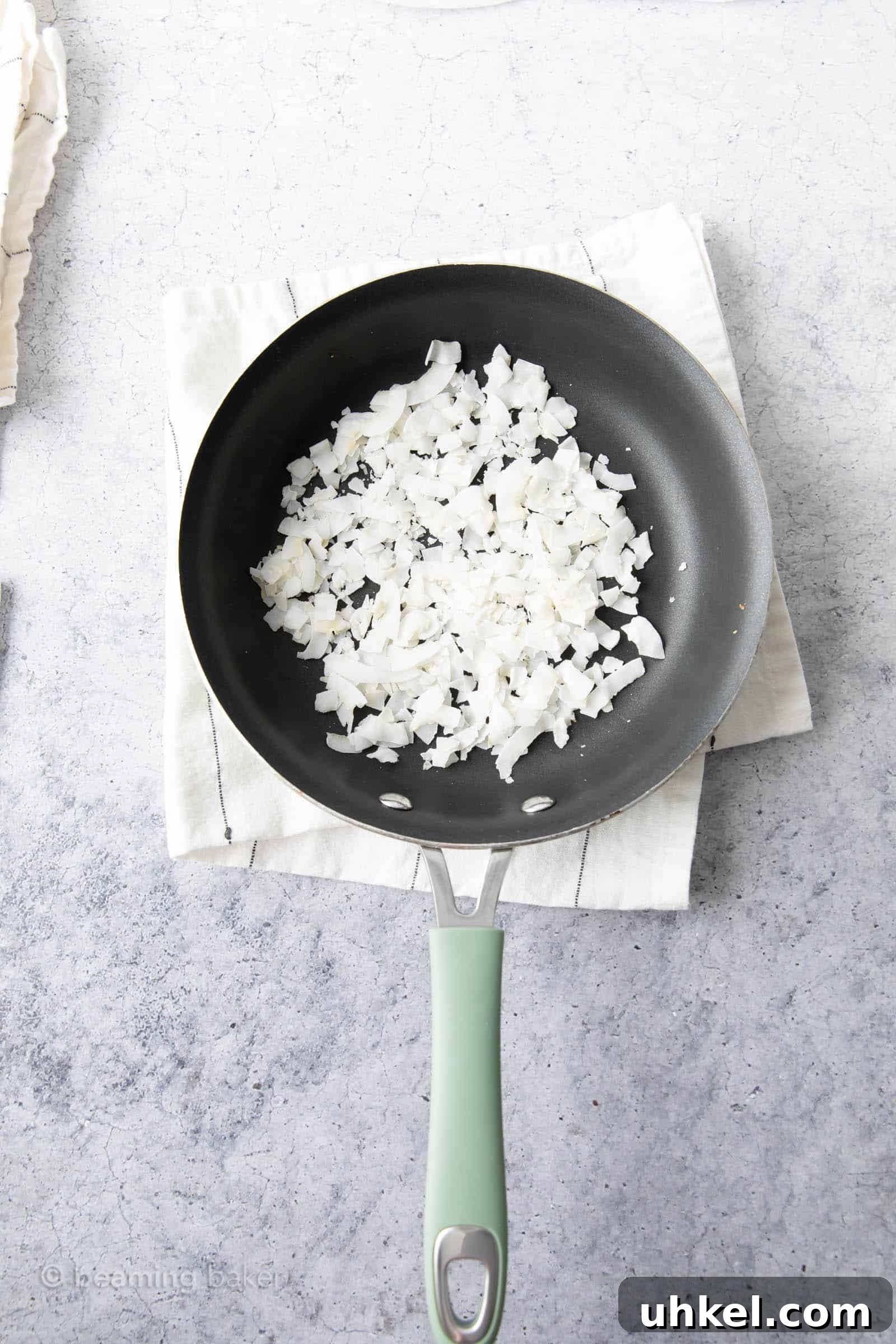 How to Toast Coconut Perfectly: Quick Oven and Stovetop Methods 4 before toasting photo of raw coconut in pan