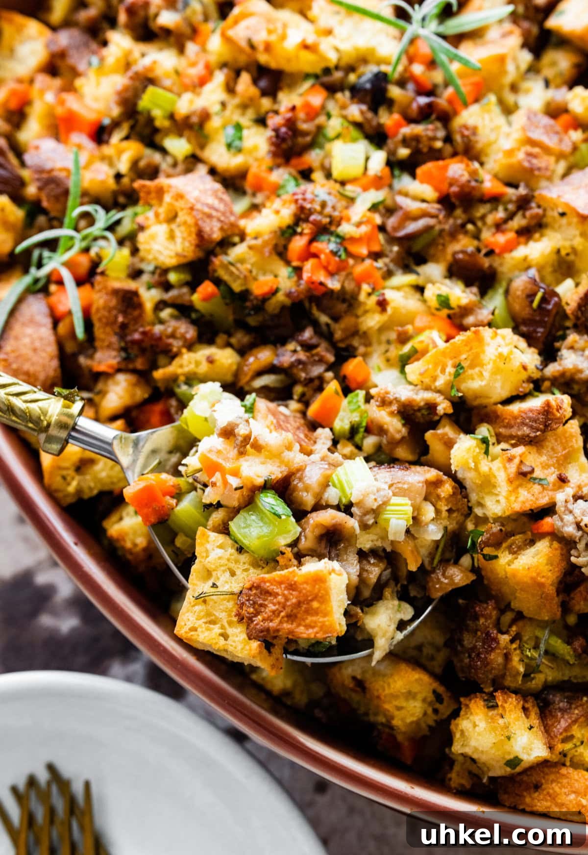 Sausage and Chestnut Ciabatta Stuffing Recipe for Holiday Tables 2 finished ciabatta bread stuffing in with sausage and chestnuts recipe. Herbs on the top and garlic on the side.