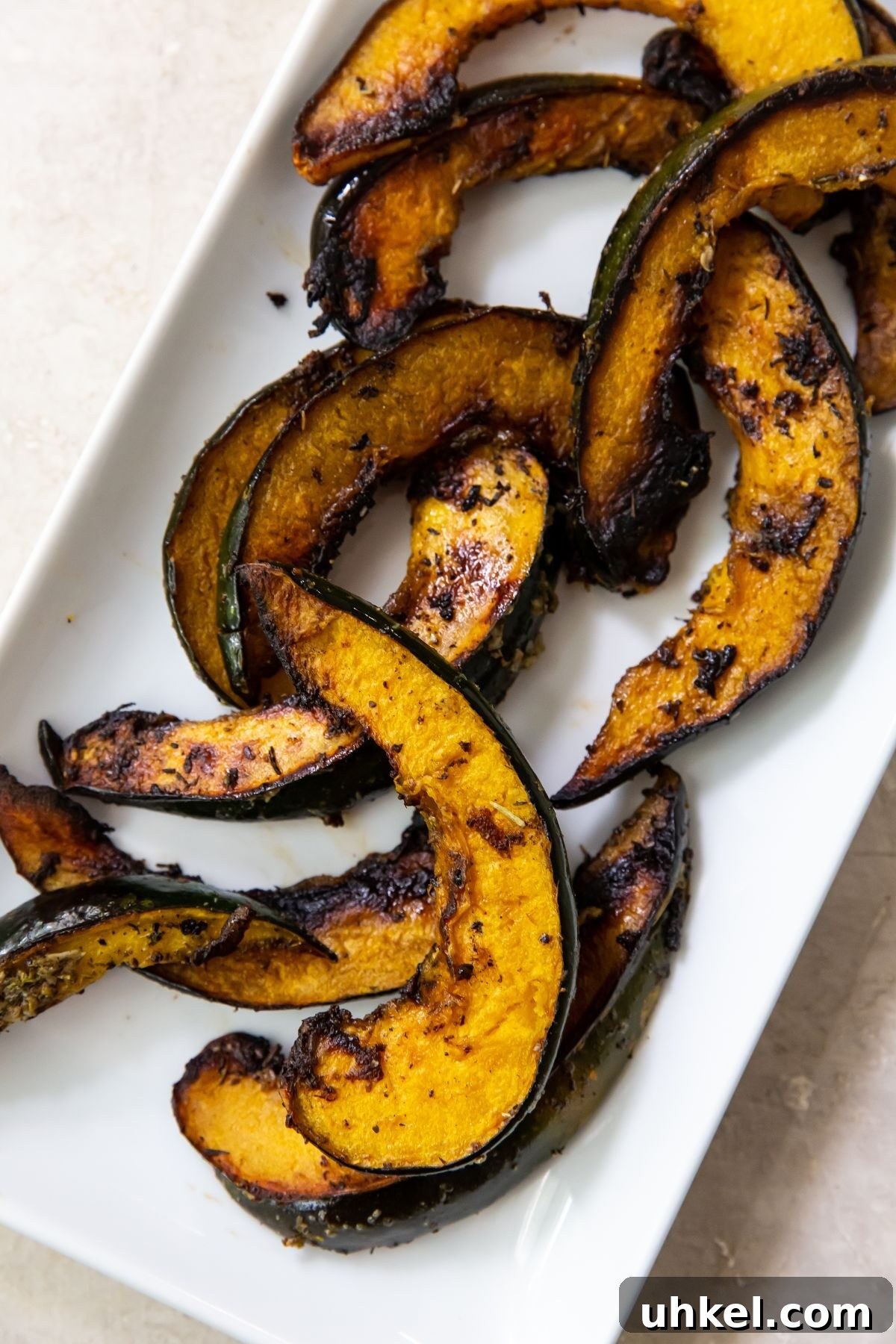 Grilled Acorn Squash on a Blackstone Grill: Smoky Fall Side Dish 2 Grilled acorn squash on a white rectangular plate