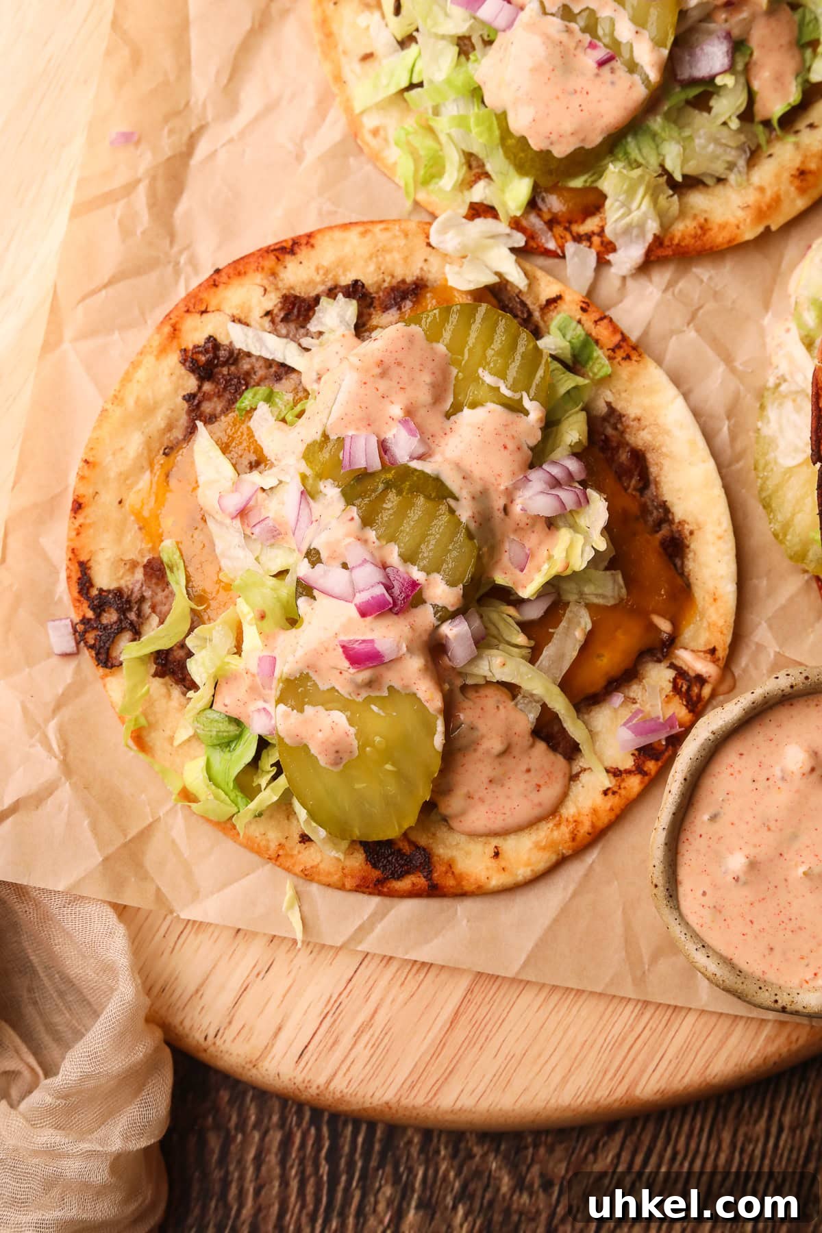 Smash Burger Tacos Recipe: Crispy Smashed Beef Tacos with Cheese 2 Smashburger tacos on a wooden cutting board.