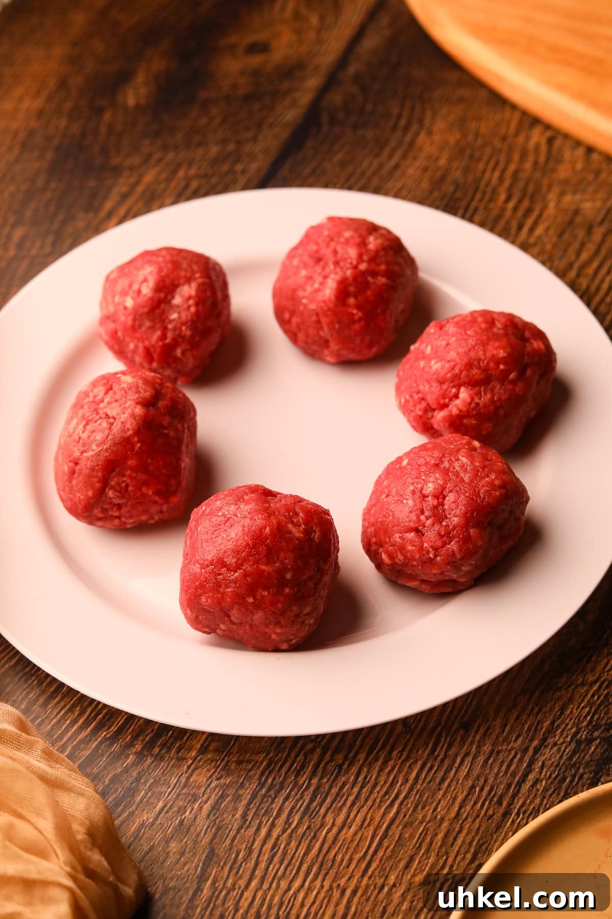 Smash Burger Tacos Recipe: Crispy Smashed Beef Tacos with Cheese 4 Ground beef balls on a plate for Smashburger tacos.