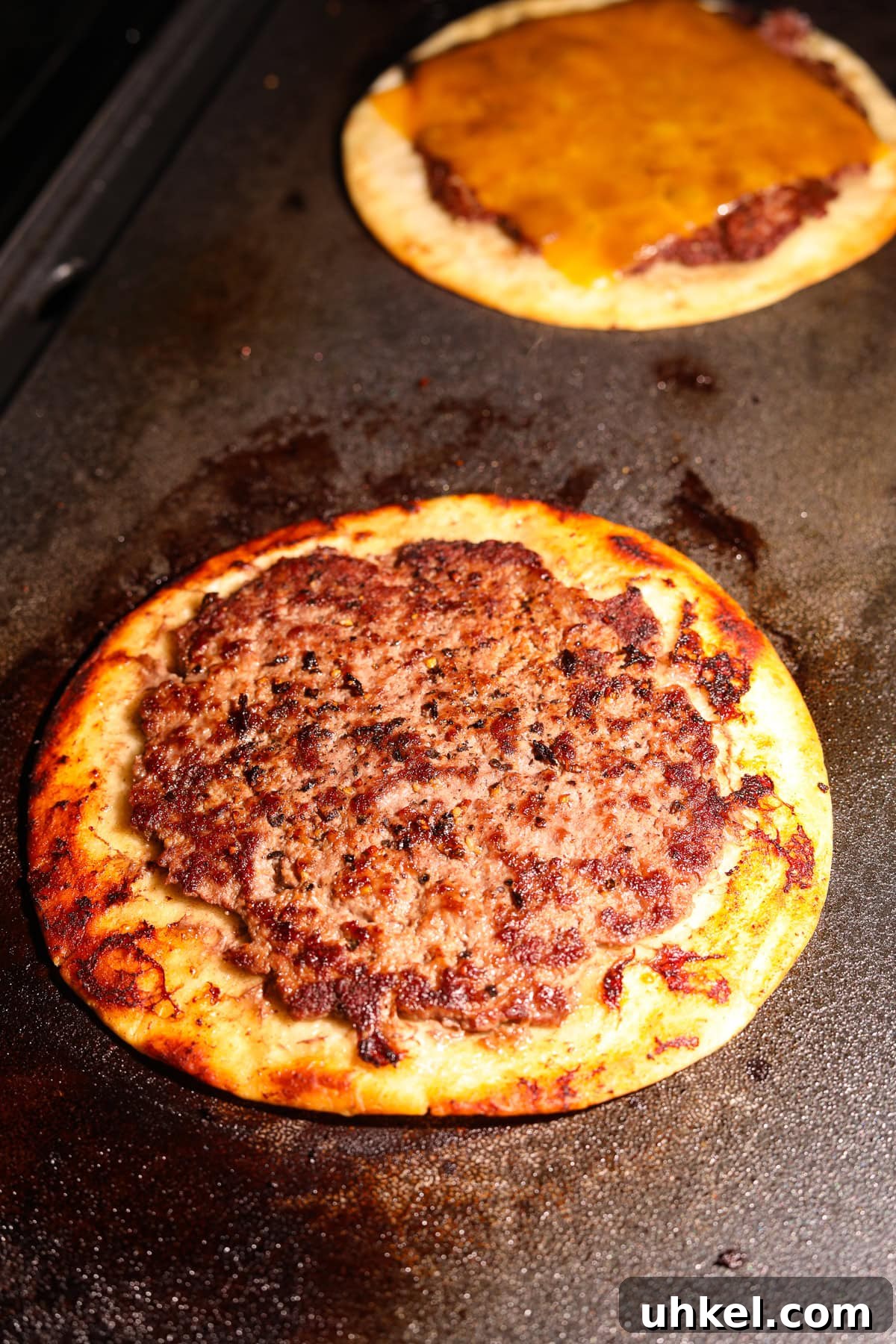 Smash Burger Tacos Recipe: Crispy Smashed Beef Tacos with Cheese 6 Smashburger tacos cooking on a griddle.