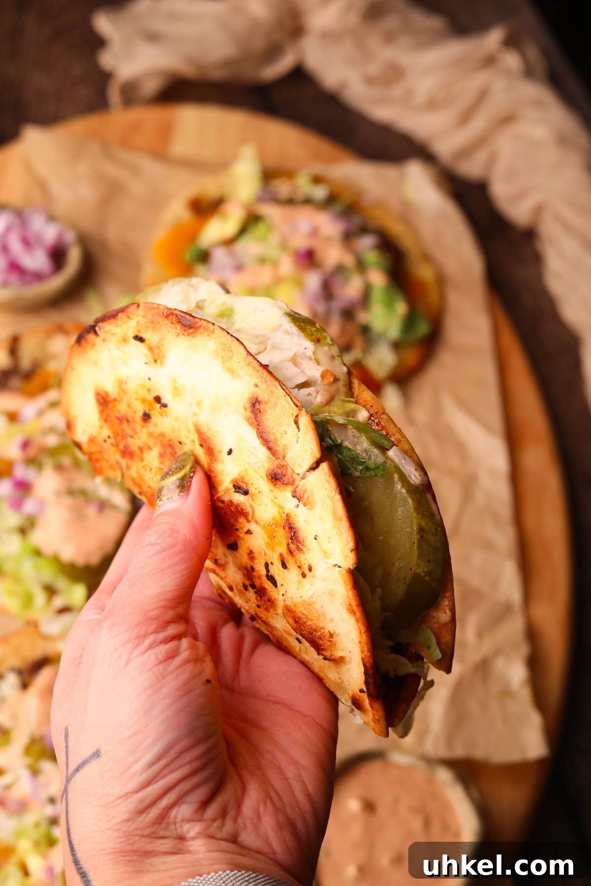 Smash Burger Tacos Recipe: Crispy Smashed Beef Tacos with Cheese 7 Folded smash burger taco held in hand.