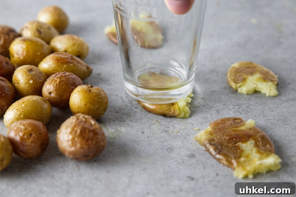 smashing cooked baby potatoes with glass