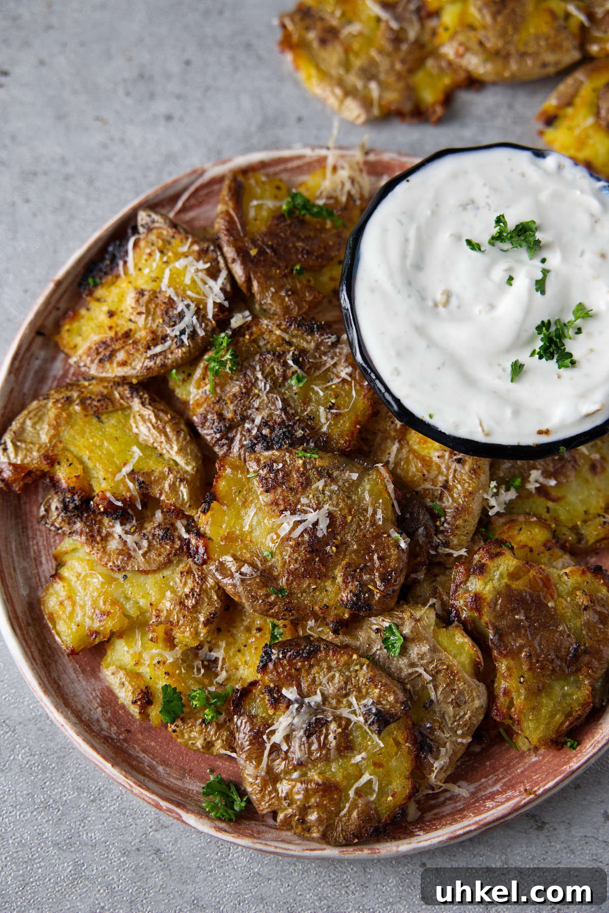 air fryer smashed potatoes plated with a bowl of dipping sauce