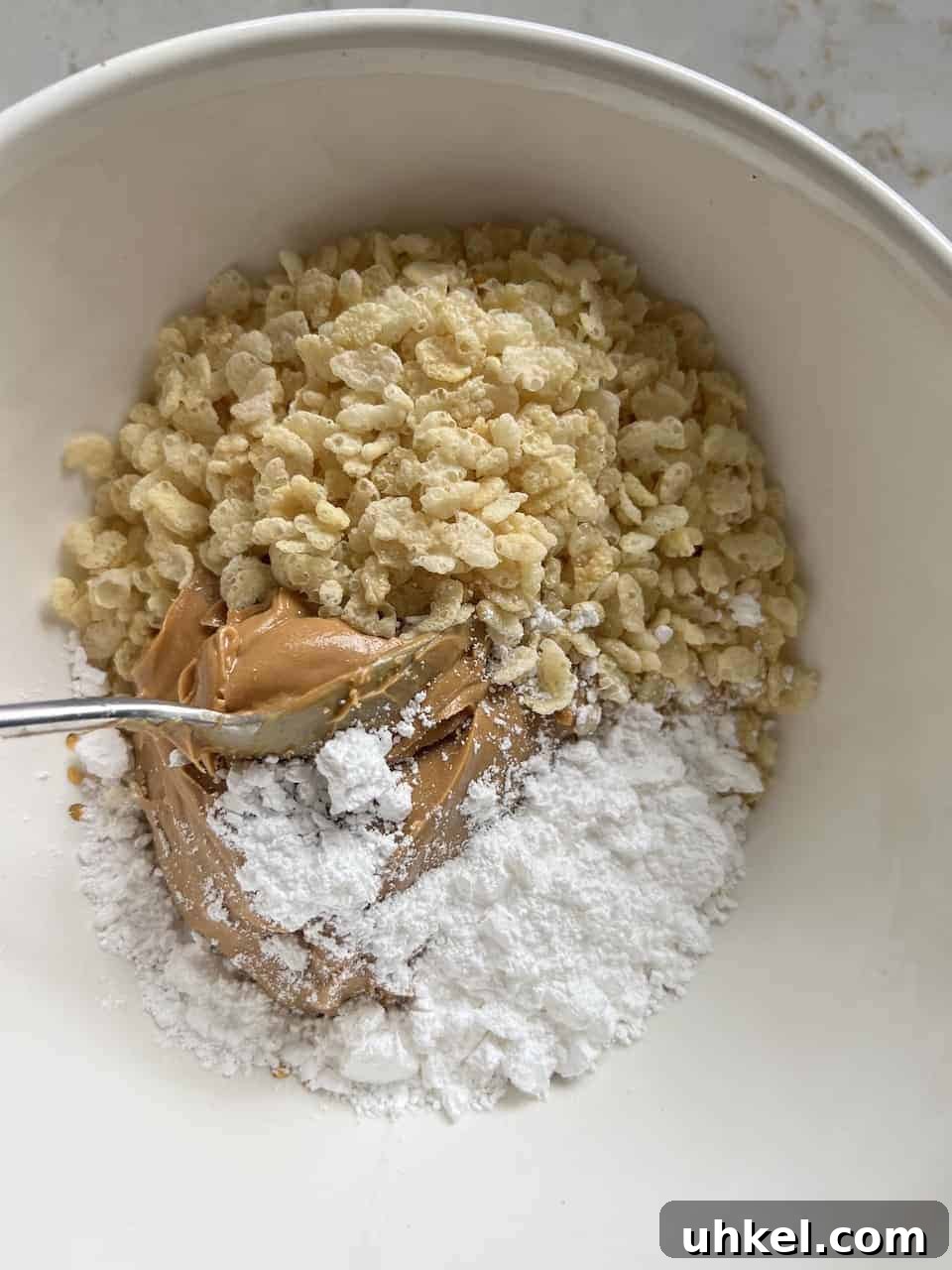 Vegan No-Bake Chocolate Peanut Butter Krispie Balls 5 process of mixing ingredients for Peanut Butter Bon Bons together in a bowl