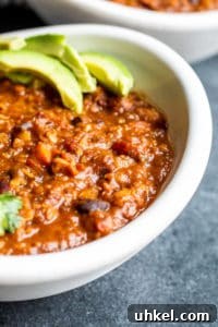 Vegetarian chili close-up. Close up shot of vegetarian chili recipe in a white bowl with avocados on top.
